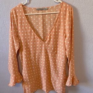 Pink polka dot blouse with waist tie and flutter sleeve.